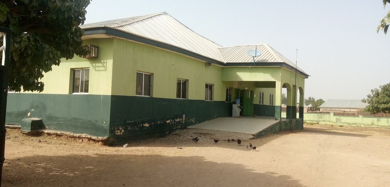 A single-storey primary health care centre painted green and cream in Gombe State